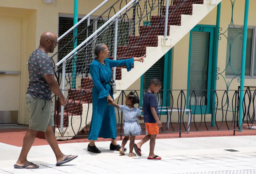 Man and two children walking in historic apartment courtyard with museum guide