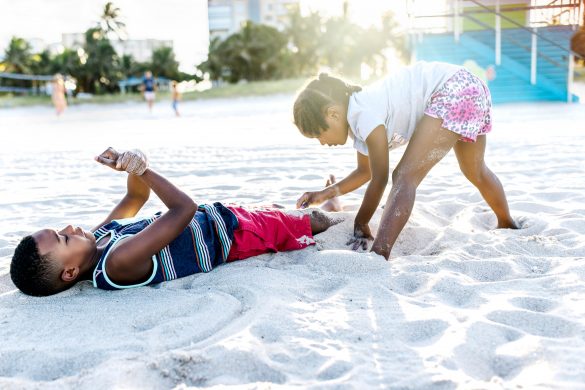 two kids playing on sand at pompano beach