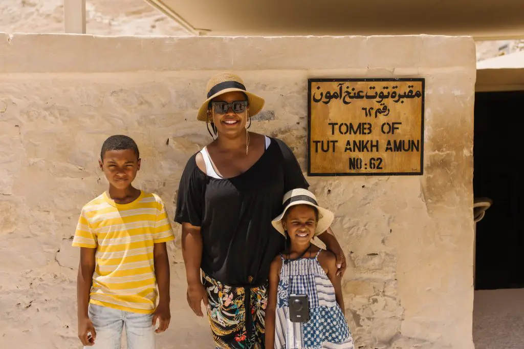 Woman and two children in front of sign for King Tut's tomb